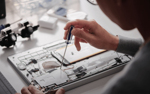 Eine Person arbeitet an einem komplexen technischen Bauteil.