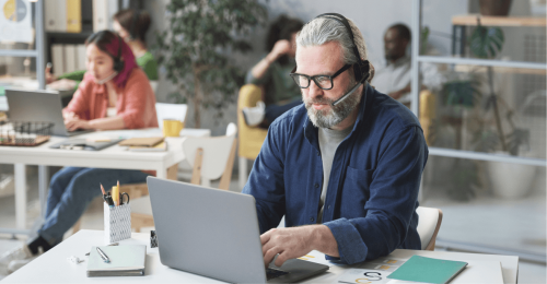 Ein Callcenteragent vor einem Laptop