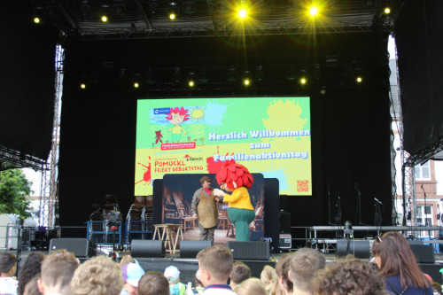 Auf der großen SR Bühne spielt Meister Eder und Pumuckl seine Show davor steht eine Gruppe von Zuschauern.