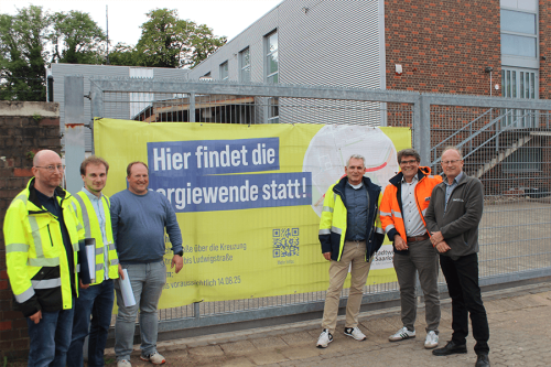 Sechs Personen posieren von einem Spanntransparent 