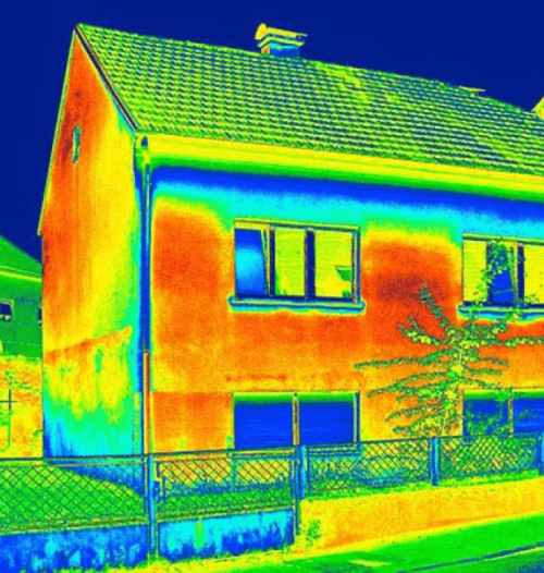 Thermografieaufnahme eines Wohnhauses mit farblicher Darstellung von Wärmeverlusten an der Fassade, Dach und Fenster.